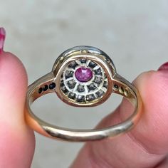 An antique gemstone ring featuring a 0.40 carat oval cut pink sapphire, bezel-set and surrounded by a double halo of old mine cut diamonds. Additional diamonds adorn the shoulders. The total diamond weight of this ring is 1.55 carats. This ring was handcrafted in silver on 14k yellow gold during the Victorian era, circa 1870. The measurements of this ring are approximately 12.21mm x 12.31mm. This ring can be resized to any finger size at no extra charge. If you have any questions about the Amien Oval Cabochon Ruby And Diamond Ring, Oval Ruby Ring With Rose Cut Diamonds, Classic Pink Ruby Ring With Halo Setting, Oval Ruby Ring With Diamond Halo, Antique Oval Ruby Ring With Brilliant Cut, Victorian Sapphire Ring With Oval Brilliant Cut, Heirloom Oval Cluster Ring With Rose Cut Diamonds, Oval Ruby Ring With Rose Cut Diamonds For Anniversary, Victorian Sapphire Ring With Diamond Oval Shape