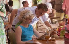 a man standing next to a woman at a table