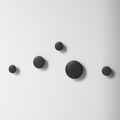 five black circles on a white wall