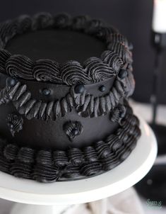 a chocolate cake with black icing on a white plate