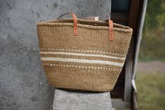 Sisal Woven Basket Bag, African Woven Market Handbag Summer Bag, Kenyan Kiondo Sisal Basket, African Purse With Leather Handles  Handwoven Sisal Basket made by the local women of the Kamba community Kenya.  The Multipurpose basket is eco friendly, durable and fashionable.  DIMENSIONS Bottom width: 12inches/ 30.48cm  Height: 12 inches/ 30.48cm  Handles: 6 inches SHIPPING All our orders ship via DHL Express (3-5 days) delivery time.  To shop more baskets: Zarabaskets.etsy.com African Purse, Sisal Basket, Basket Handbag, Market Bags, Handmade Baskets, Summer Bag, Woven Basket, Basket Bag, Market Bag