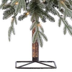 a small christmas tree with lights on it's branches in a metal stand against a white background