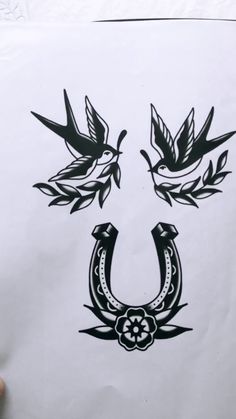 a drawing of two birds on top of a white sheet with black ink and some leaves