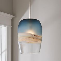 a blue and white glass light hanging from a ceiling