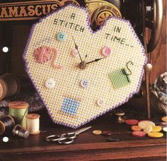 a heart shaped clock with buttons and thread on it