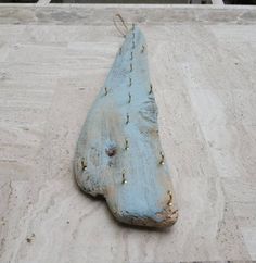 a blue piece of wood sitting on top of a cement floor next to a building