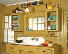 a kitchen with yellow cabinets and white sink