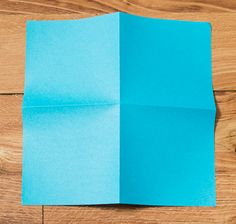 an open blue piece of paper sitting on top of a wooden floor