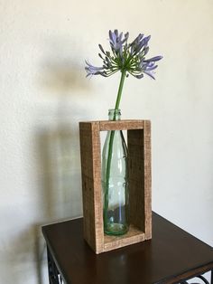 a vase with purple flowers in it sitting on a table