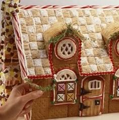 a gingerbread house made to look like it is being held by someone's hand