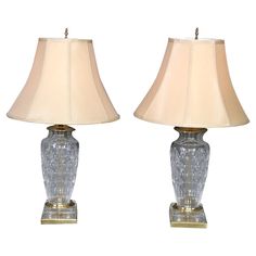 two clear glass lamps sitting next to each other