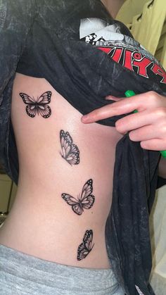 a woman with butterfly tattoos on her stomach