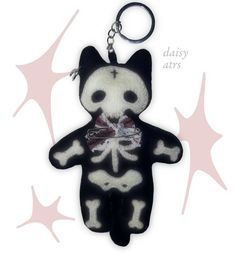 a key chain with a black and white cat wearing a bow tie on it's neck