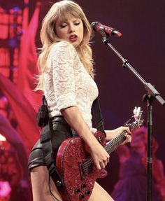 taylor swift performing on stage with her guitar