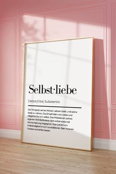 a poster on the floor in front of a pink wall that says selbst - liebe