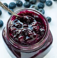 blueberry sauce in a jar with a spoon