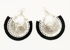 two pairs of black and white earrings with fringes on the bottom, one has a circular