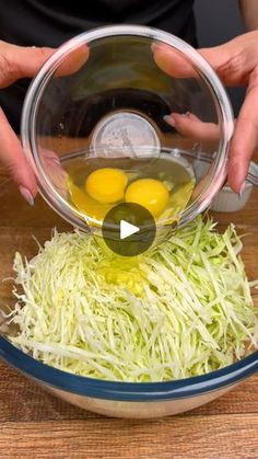 someone is adding eggs to shredded cabbage in a bowl