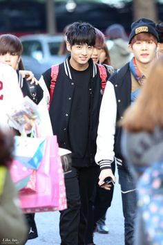 two young men walking down the street with shopping bags