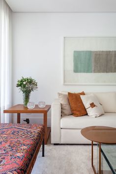 a living room with a couch, coffee table and painting on the wall above it