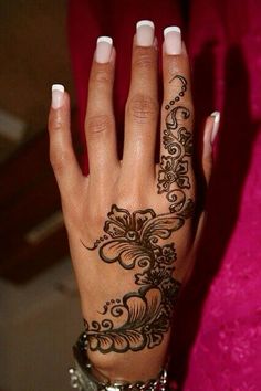 a woman's hand with henna tattoos on it