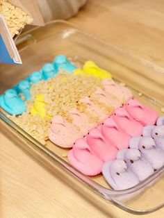 a plastic container filled with rice and peeppies on top of a wooden table