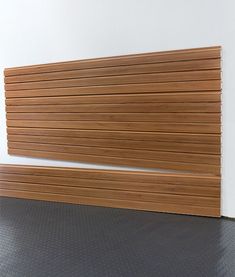 a wooden slatted wall next to a white wall