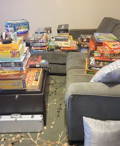 a living room filled with lots of books and video game controllers on top of couches