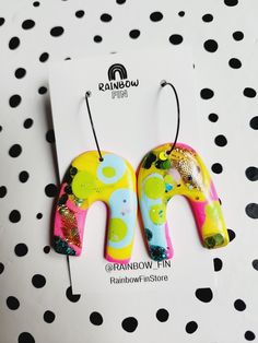 the earrings are made out of polymer and have colorful designs on them, along with black polka dots