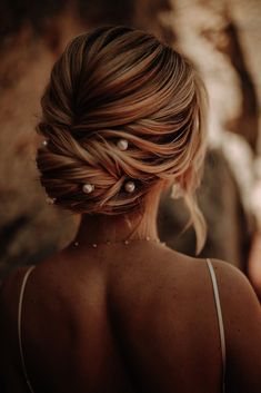 the back of a woman's head with pearls in her hair