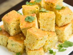 a plate full of cornbreads with cilantro garnish on top