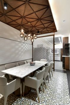 a dining room with a table and chairs in front of a wall mounted light fixture