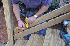 a man is working on some wooden steps with yellow handles and pliers in his hands