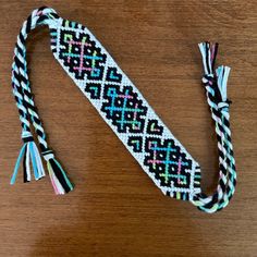 a colorful beaded bracelet with tassels on a wooden table