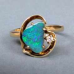 Abstract Vintage 18ct Gold Black Opal Ring. Beautiful Ring consisting of a black opal doublet 9 x 6mm cut in irregular shape, together with a 2point brilliant cut diamond encased in an abstract gold heart setting. The black opal is displaying good colours or mainly blue and green. The total face of the ring measures 13mm x 12mm and the band is good and strong and stamped for 750.   Well made quality ring in excellent as new condition. Shank is stamped for 750  but no date stamp and probably date Jewellery Images, Opal Heart Ring, Antique Rings Vintage, Date Stamp, Black Opal Ring, Jewelry Images, Modern Gift, Opal Ring, Beautiful Ring