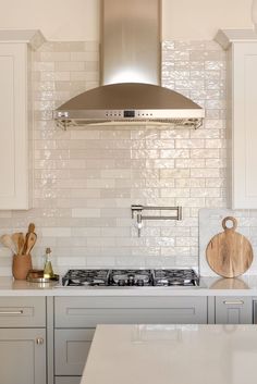 a stove top oven sitting inside of a kitchen next to a wooden board and cutting board