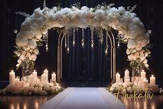 a wedding arch with candles and flowers on the floor in front of a black backdrop