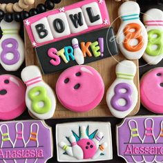 decorated cookies with bowling pins and numbers are displayed on a board for the party guests to enjoy