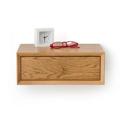 a small wooden shelf with a clock and glasses on it's top, next to a pair of eyeglasses