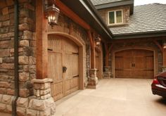 a car is parked in front of a house with two garage doors on each side