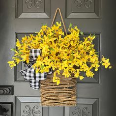 a basket filled with yellow flowers hanging from a door