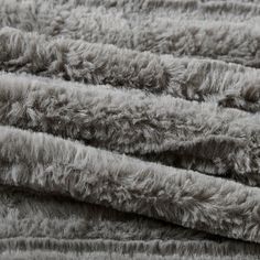 a pile of grey shaggy rugs on top of each other