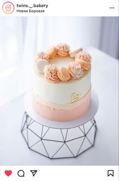 a white and pink cake sitting on top of a table