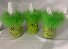 three green plastic cups with furry ears and grin face on the top one has yellow eyes