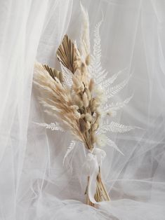 some dried flowers are sitting on a white cloth