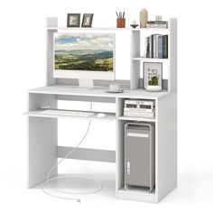 a computer desk with a monitor, keyboard and speakers on it in front of a white background