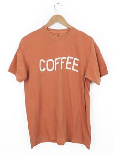 This Wavy Coffee design T-shirt is the perfect little pick-me-up! It's printed on the comfiest Comfort Colors tee, with the perfect vintage look. True to size or size up to rock the oversized look. A total must-have for any true coffee connoisseur! You can select the size and shirt color and we will make this shirt just for you. Since this shirt is made just for you please allow 2-3 weeks for your order to ship out. Retro T-shirt For Everyday Fall Wear, Brown Grunge Crew Neck T-shirt, Vintage Graphic Print T-shirt For Fall, Coffee Colored Relaxed Fit T-shirt With Slogan, Oversized Acid Wash Vintage T-shirt, Vintage Acid Wash Tops For Everyday Wear, Brown Graphic Tee With Text Print, Acid Wash Short Sleeve T-shirt With Slogan, Retro Letter Print T-shirt For Everyday