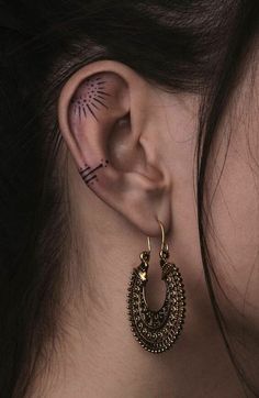 a close up of a person's ear with piercings on top of it