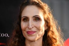 a close up of a person with long hair and wearing a black dress at an event