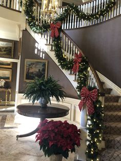 christmas decorations on the banisters and stairs in a house with red poinsettias